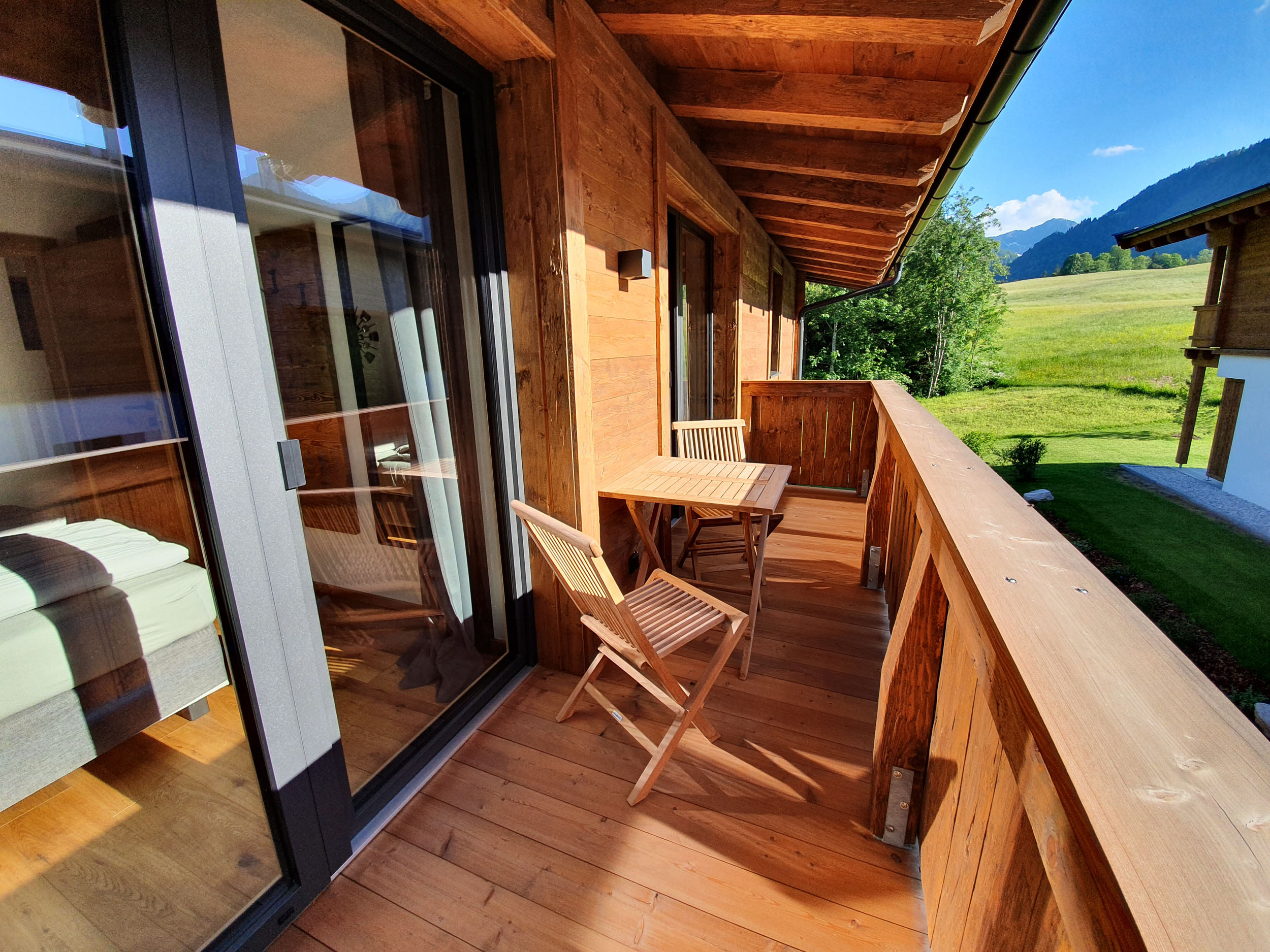 Balkon mit Esstisch, Stühlen und weitem Blick ins Pillerseetal