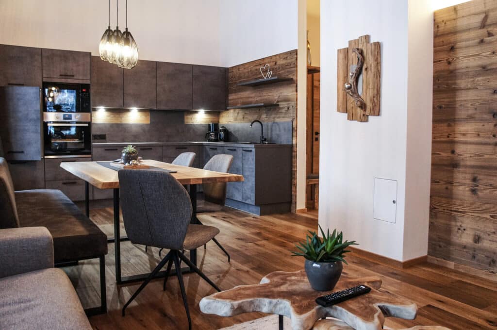 Offene Wohnküche im Chalet Zeitfrei mit Holzboden, moderner Einrichtung und gemütlichem Essbereich.