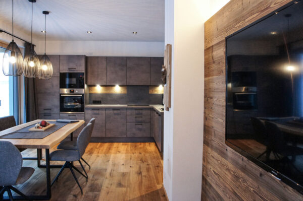 Küchenzeile, Essplatz und TV im Chalet-Apartment