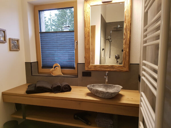 Modernes Bad, Steinwaschbecken, Spiegelrahmen aus Holz und Handtücher bereit