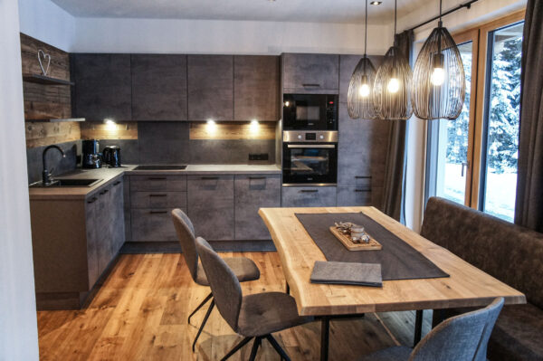 Offene Küche und Esstisch mit Blick auf Schneelandschaft