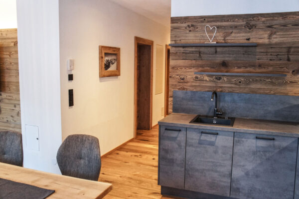 Kompakte Küchenzeile in Altholz mit stilvoller Natursteinspüle im Chalet