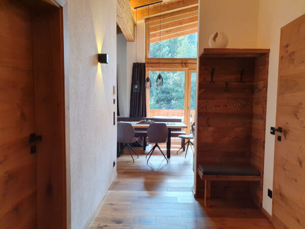 Flur mit Altholzverkleidung führt zum hellen Wohnraum